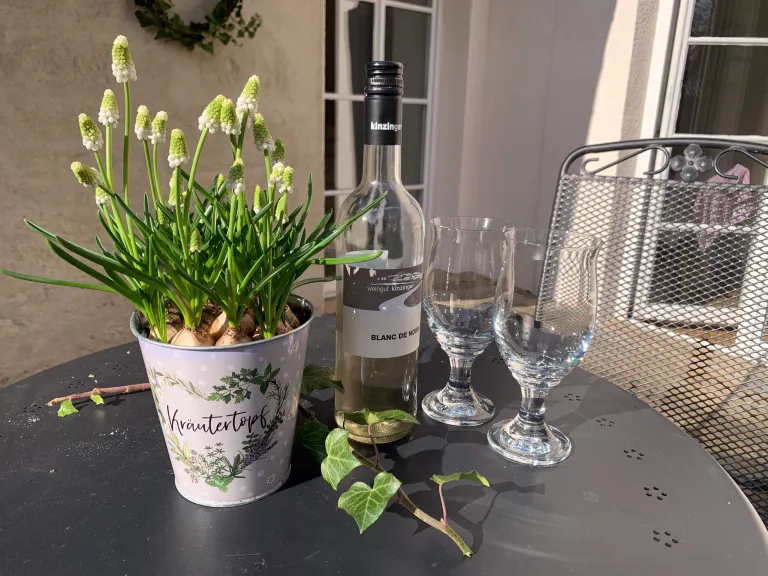 Wein und Blumen auf dem Gartentisch
